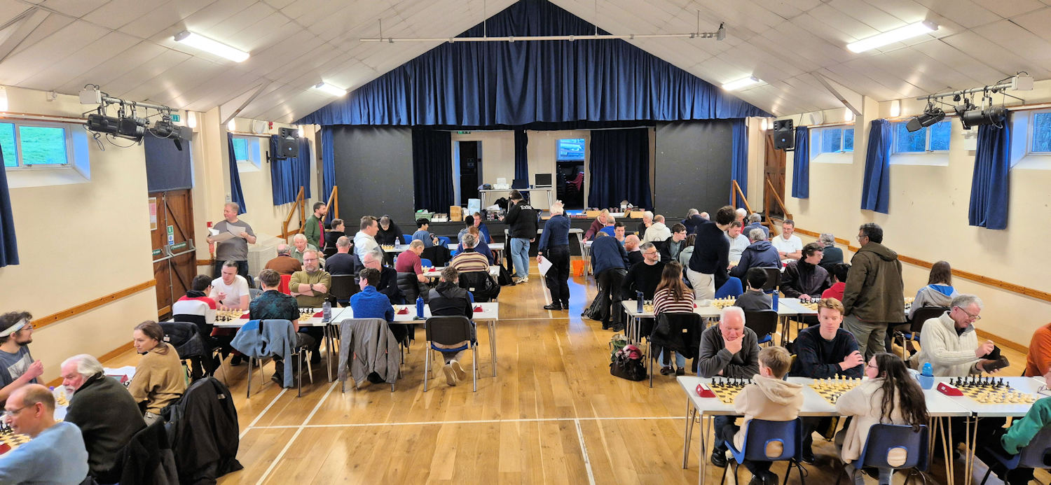 A hall of people sitting ready to play chess